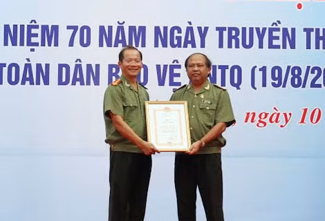 Trung tướng Bùi Xuân Sơn (bên phải) trao chứng nhận công trình kỷ niệm 70 năm ngày truyền thống CAND cho lãnh đạo Công an tỉnh Hậu Giang.
