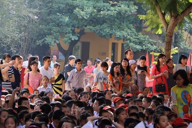 Các phụ huynh dõi theo con em mình tới trường khai giảng