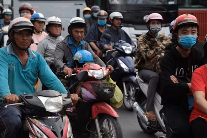 Một em bé ngủ trên xe máy.
