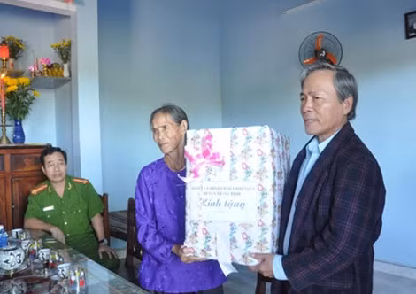 Đại diện Huyện ủy, UBND huyện Thăng Bình tặng quà bà Nguyễn Thị Minh.