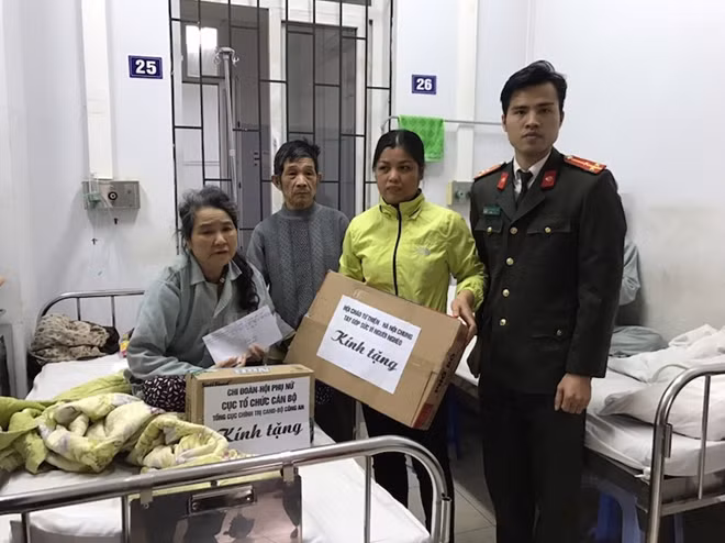 Thượng úy Đinh Quang Hoạch, Phó Bí thư Đoàn Thanh niên Cục Tổ chức cán bộ tặng quà bà Vũ Thị Vui, bệnh nhân tại Khoa Nội, Trung tâm Tim mạch, Bệnh viện E