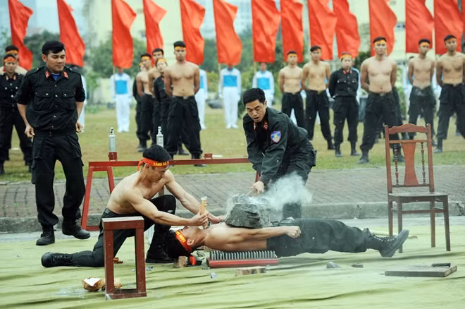 Nằm trên bàn chông công phá đá trên phần bụng, lưng