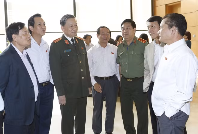 Bộ trưởng Tô Lâm trao đổi với các đại biểu bên hành lang Quốc hội