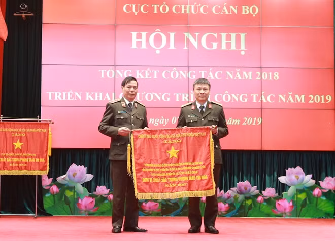 Thiếu tướng Đinh Huy Hiệu thừa uỷ quyền của Thủ tướng Chính phủ trao Cờ thi đua xuất sắc tặng Phòng Chính sách người có công và hậu phương CAND