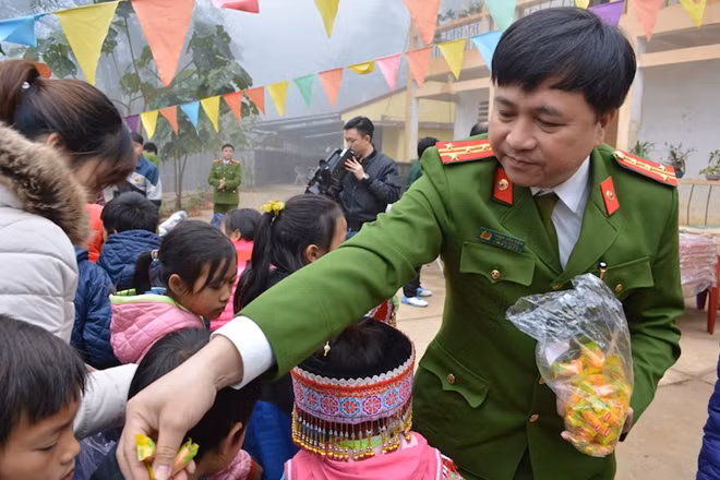 Đại tá Phạm Văn Năm tặng quà cho các em học sinh của xã
