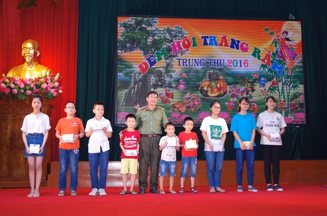 Đại tá Nguyễn Văn Quế - Phó Hiệu trưởng trao quà của nhà trường cho các cháu thiếu niên, nhi đồng