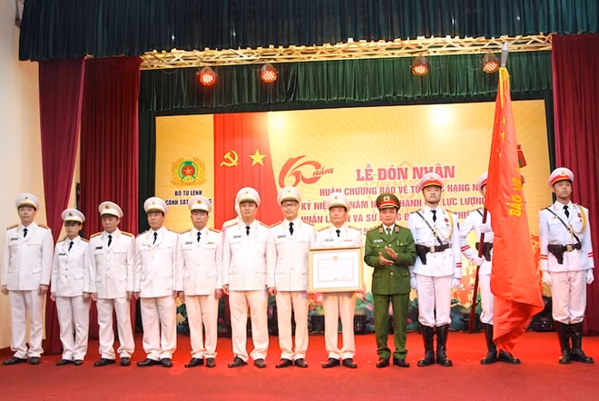 Thừa uỷ quyền của Chủ tịch nước và lãnh đạo Bộ Công an, Trung tướng Phạm Quốc Cương, Tư lệnh CSCĐ gắn Huân chương lên Cờ truyền thống và trao Bằng Huân chương cho tập thể Trung tâm Huấn luyện và sử dụng động vật nghiệp vụ.