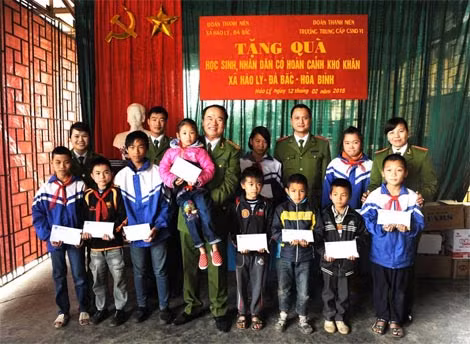 Đại tá, GS Nguyễn Hữu Duyện, Hiệu trưởng Trường Trung cấp CSND VI trao tặng 10 phần quà cho 10 em học sinh tiêu biểu có hoàn cảnh khó khăn nhưng đạt thành tích cao trong học tập.