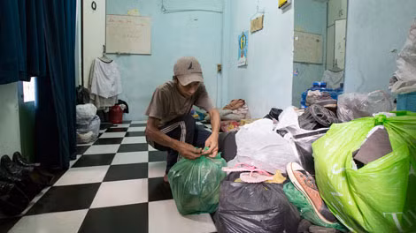 Căn phòng nhỏ vừa là nơi ngủ, vừa là nơi chứa đồ, vừa là kho hàng từ thiện của anh Lý Ngọc Bình. Tiện nghi hiện đại duy nhất là chiếc radio cũ, và nhờ nó anh Bình mới có cơ hội gặp bạn gái qua chương trình kết bạn.