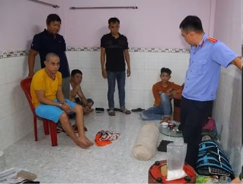 Các đối tượng (ngồi dưới sàn) cùng tang vật vụ án.
