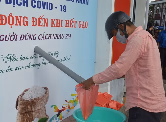 Người dân có hoàn cảnh khó khăn đến nhận gạo sáng 22/4.