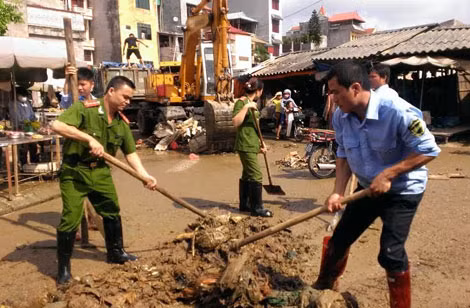 Ban quản lý chợ phối hợp lực lượng Công an TP Lạng Sơn và người dân dọn dẹp, vét nạo bùn, rác ngập ngụa trong chợ Giếng Vuông sau khi cơn bão số 2 năm 2014 đi qua.