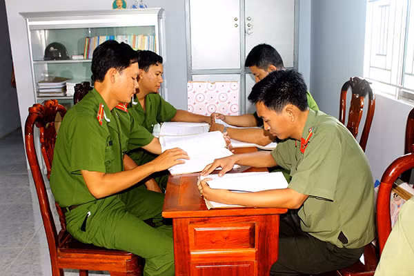 Nhiều CBCS Công an huyện cùng ngồi làm việc trên chiếc bàn nhỏ.