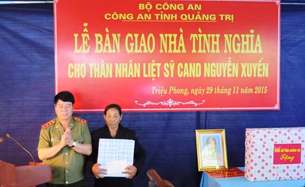 Thứ trưởng Bùi Văn Nam tặng quà vợ liệt sĩ Nguyễn Xuyến.