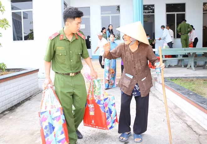 Niềm vui nhân đôi của một người dân khi nhận quà được các chiến sĩ giúp đưa ra tận xe.