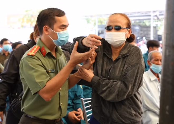 Một người dân gặp khó khăn khi di chuyển lên nhân quà Tết được cán bộ chiến sĩ hỗ trợ