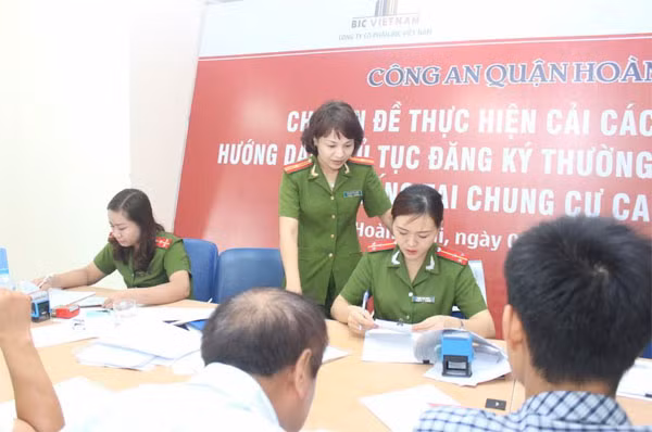 Thiếu tá Lê Thị Thu Hiền, Phó đội trưởng Đội Cảnh sát QLHC về TTXH, Công an quận Hoàng Mai đôn đốc cán bộ thực hiện thủ tục nhanh gọn, thuận tiện cho người dân.