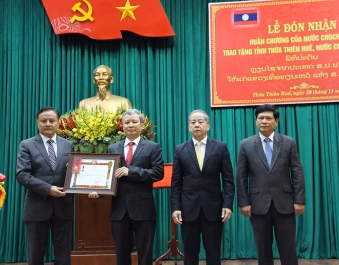 Thừa ủy quyền Chủ tịch nước CHDCND Lào, ông Santiphap Phomvihan (góc trái) trao Huân chương Lao động hạng Nhất cho tỉnh Thừa Thiên- Huế.