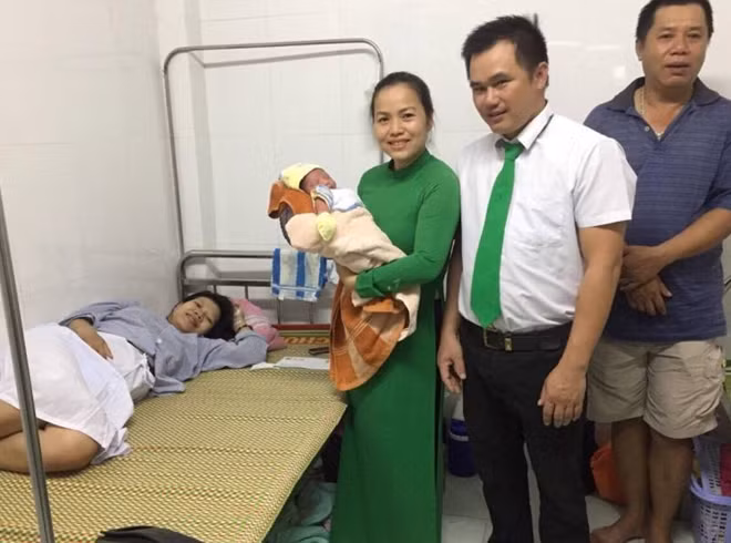 Tài xế Lê Phước Chính bên gia đình sản phụ Ngọc sau khi giúp chị Ngọc “vượt cạn” trên xe taxi.
