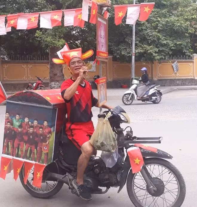 Ông Mẫn vừa bán bánh mì dạo vừa cổ vũ cho đội tuyển Việt Nam chiến thắng trong trận gặp đội tuyển Hàn Quốc vào 16h chiều nay.