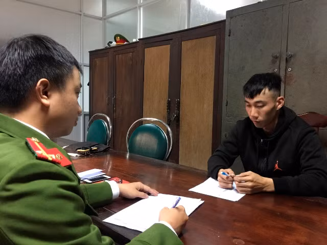 Cơ quan công an lấy lời khai một trong các đối tượng trong đường dây lừa đảo.