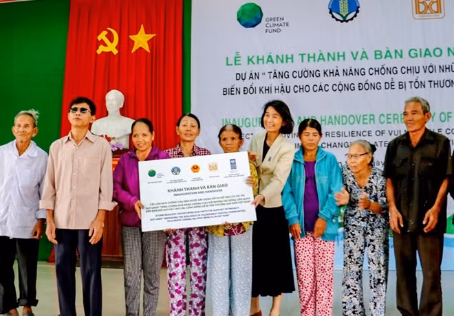 Đại diện Chương trình Phát triển Liên Hợp Quốc tại Việt Nam trao biển tượng trưng về bàn giao nhà chống bão lũ cho người dân ở Thừa Thiên- Huế.