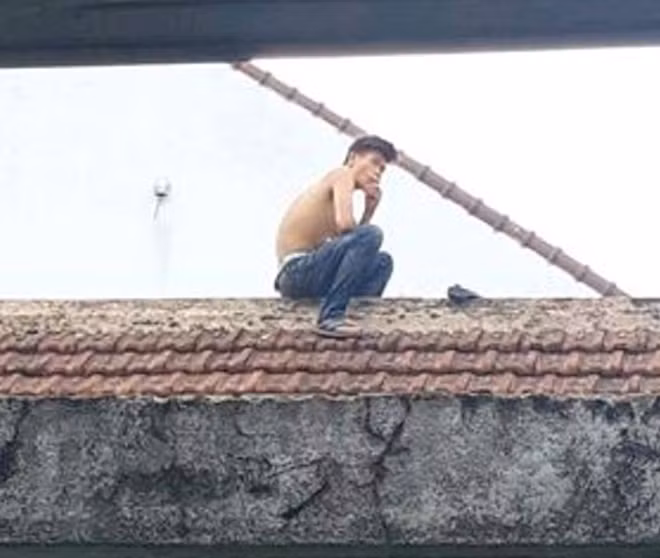Đối tượng Long cố thủ trên nóc nhà.