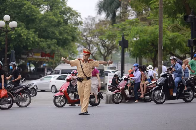 Một CSGT nỗ lực điều tiết giao thông trên đường phố Huế vào giờ cao điểm.