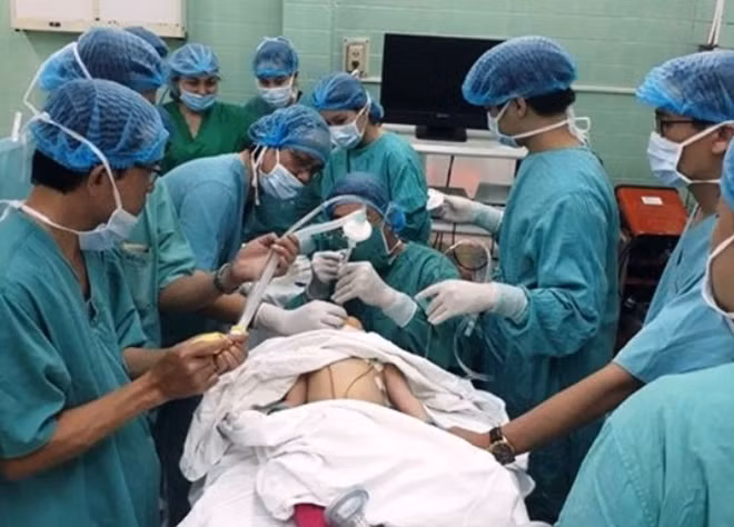 Ê kip y, bác sĩ Bệnh viện Trung ương Huế tiến hành nội soi lấy hạt dưa ra khỏi phế quản cháu T..