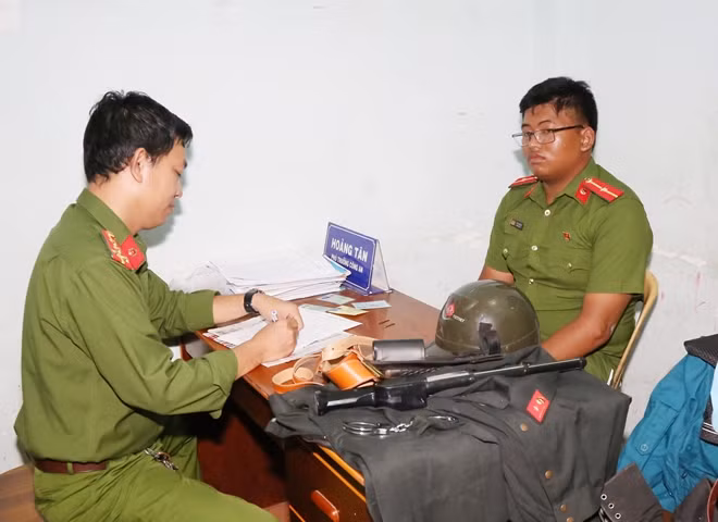 Đối tượng Đệ (bên phải) tại cơ quan Công an, cùng trang phục CAND đặt mua trên mạng.