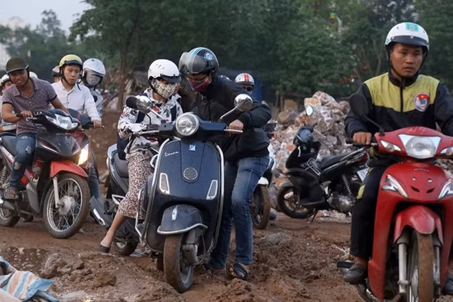 Do dự án mương thoát nước đang thi công, cộng với trời mưa nên con đường ven mương ngập bùn đất. Một số phương tiện qua đây gặp khó khăn, nhiều người bị ngã phải xuống dắt xe. "Đây không phải là lựa chọn sáng suốt nhưng do quá vội nên phải đi tắt vào con đường này để vượt qua ùn tắc", anh Trần Tuấn ở khu đô thị mới Dương Nội chia sẻ.
