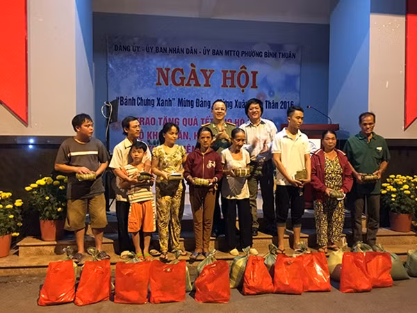 Đại tá Nguyễn Thanh Hải, Trưởng Cơ quan Đại diện Báo CAND phía Nam, ông Lưu Quốc Cường trao quà Tết cho bà con phường Bình Thuận, TP HCM.