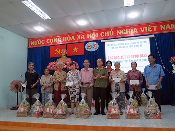 Đại tá Trần Kim Thẩm, PTBT Báo CAND, Cơ quan đại diện tại TP HCM chụp hình lưu niệm với bà con.