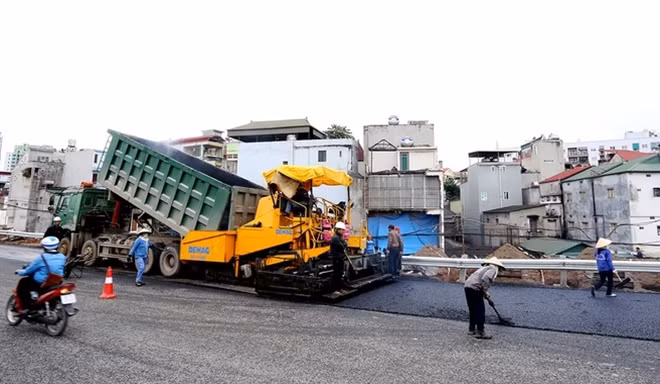 Một số đoạn đang được thảm nhựa trong buổi sáng nay trên đường dẫn lên cầu Hoàng Quốc Việt - Bưởi.