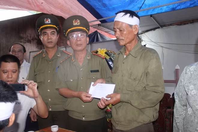 Đại tá Đặng Văn Lân trao tiền hỗ trợ cho gia đình bà Phúc.