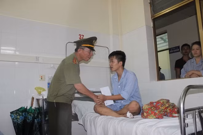 Đại tá Đặng Văn Lân trao tiền hỗ trợ những người bị thương đang điều trị tại bệnh viện.