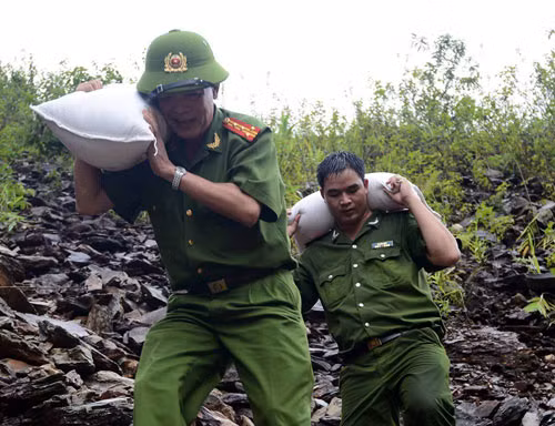 Cán bộ Công an tỉnh Điện Biên gùi gạo tiếp tế cho người dân bản Hua Mức 2, xã Pú Xi, Tuần Giáo. Ảnh: Hoàng Anh