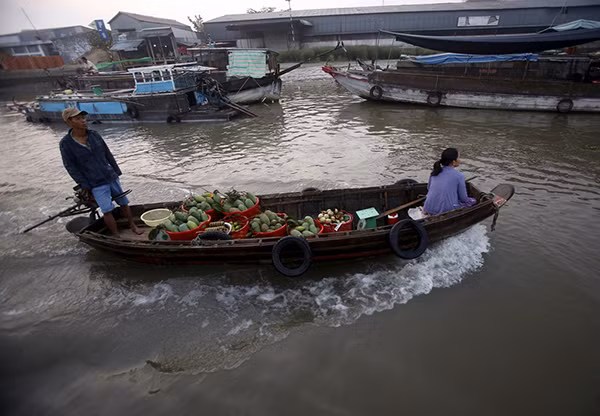 Người dân chở hàng hóa trên sông Hậu ở Cần Thơ. Ảnh Reuters. Người dân chở hàng hóa trên sông Hậu ở Cần Thơ. Ảnh Reuters.