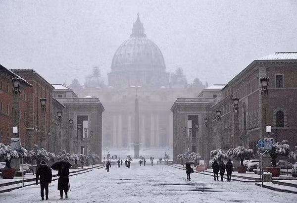 Dòng người đi trên Quảng trường St Peter trắng tuyết ở Vatican.