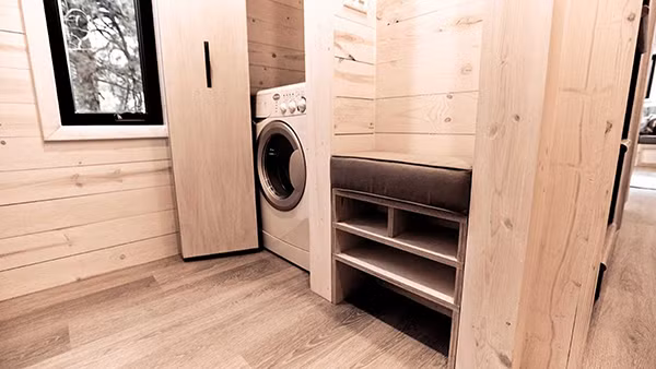 Bên cạnh khoang đặt máy giặt là tủ để đồ được bố trí hợp lý.