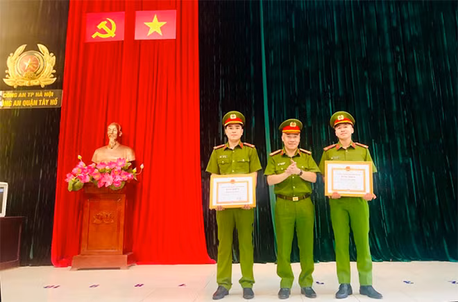 Thừa uỷ quyền của Chủ tịch UBND TP Hà Nội, Đại tá Mai Trọng Thắng trao thưởng cho 2 cán bộ Công an quận Tây Hồ.