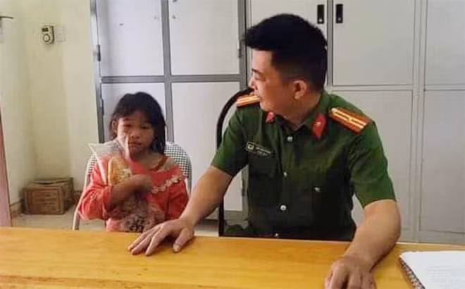 Bé gái bị lạc trong rừng được Công an xã Háng Đồng đưa về trụ sở chăm sóc.