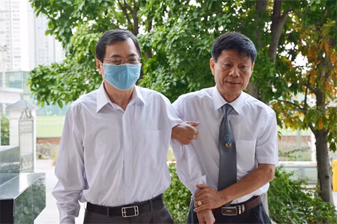 Bị cáo Vũ Huy Hoàng được dìu vào phòng xử án.