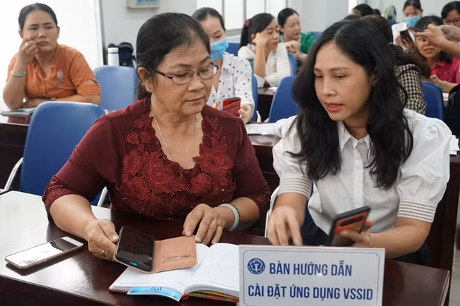 Cán bộ Bảo hiểm xã hội TP Hồ Chí Minh hướng dẫn cho người dân tham gia cài đặt ứng dụng VssID.