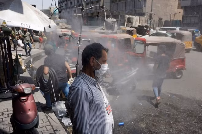 Người Iraq đứng dưới vòi phun sương để hạ nhiệt trong mùa hè nắng nóng kỷ lục. Ảnh: Getty Images.