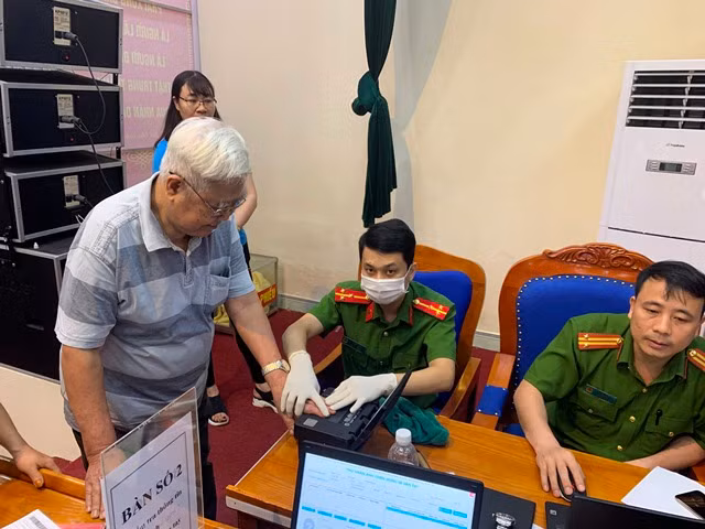 Ông Quản Đức Nghiêm, 80 tuổi nhanh chóng được các cán bộ tổ cấp CCCD lưu động lấy mẫu vân tay.