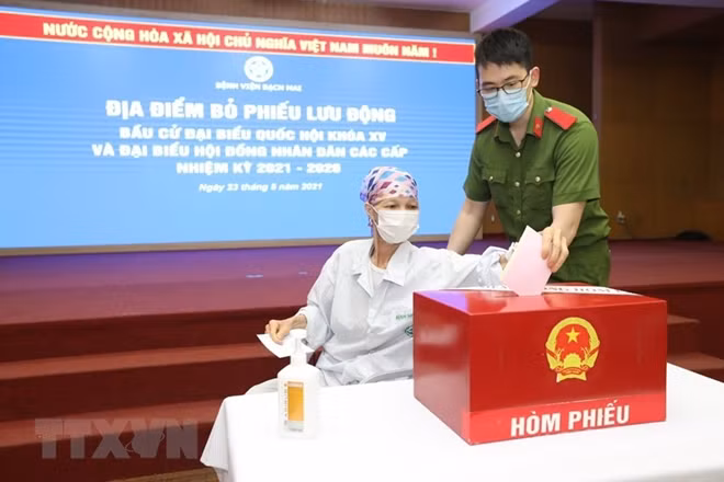 Cử tri bỏ phiếu tại địa điểm bỏ phiếu lưu động tại Bệnh viện Bạch Mai. (Ảnh: Minh Quyết/TTXVN)