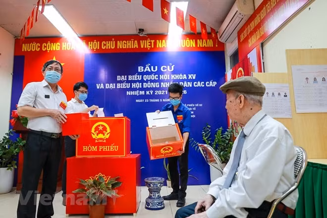 Trong ngày bầu cử, trước khi tiến hành việc bỏ phiếu, Tổ bầu cử phải kiểm tra hòm phiếu trước sự chứng kiến của cử tri để bảo đảm tính công khai, khách quan và thực hiện nguyên tắc nhân dân kiểm tra. Đây cũng là hình thức để cử tri trực tiếp giám sát cuộc bầu cử. (Ảnh: Minh Sơn/Vietnam+)