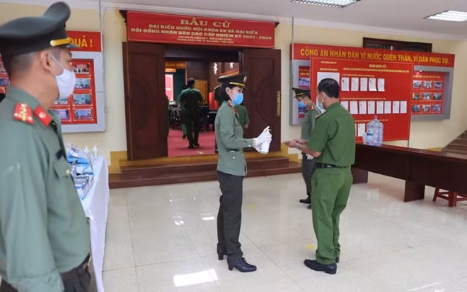 Cử tri được kiểm tra thân nhiệt và sát khuẩn tay trước khi vào khu vực bỏ phiếu.