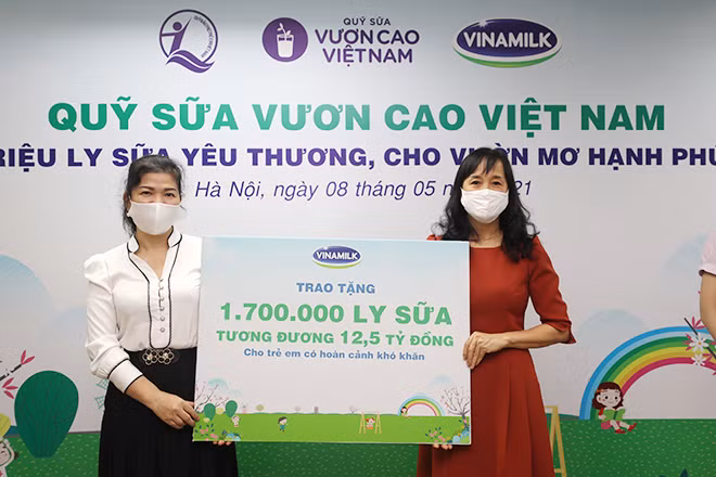 Đại diện Vinamilk trao bảng tượng trưng 1,7 triệu ly sữa của Quỹ sữa Vươn cao Việt Nam cho Đại diện Quỹ bảo trợ trẻ em Việt Nam.